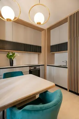 a kitchen with a wooden table and blue chairs at Adriatic Dream Apartment Becici in Budva
