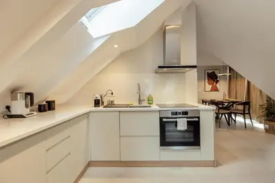 an attic kitchen with white cabinets and a skylight at Kotor Central Point in Kotor