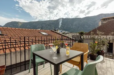a table with two glasses of wine on a balcony at Kotor Central Point in Kotor