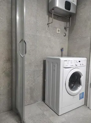 a washer and dryer in a corner of a bathroom at Studio K in Podgorica