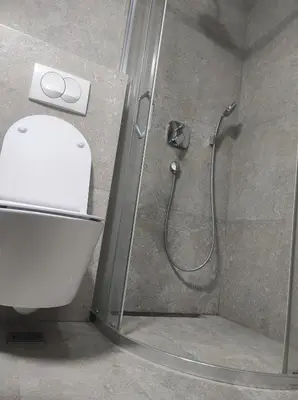 a bathroom with a shower with a toilet and a glass door at Studio K in Podgorica