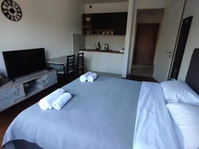a bedroom with a blue bed with three pillows on it at Studio K in Podgorica