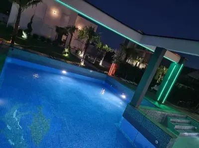 a swimming pool at night with lights on a house at Villa „Taki“ Podgorica in Podgorica