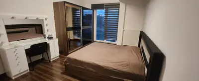 a bedroom with a bed and a desk and a window at Villa „Taki“ Podgorica in Podgorica