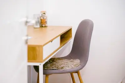 a desk with a chair next to a white wall at The Rooftop of Apartments Lungo Mare in Ulcinj