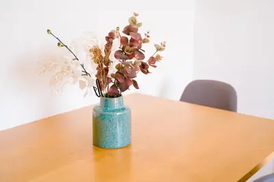 a blue vase with flowers in it on a table at The Rooftop of Apartments Lungo Mare in Ulcinj