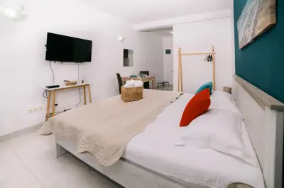 a bedroom with a large bed with a flat screen tv at The Rooftop of Apartments Lungo Mare in Ulcinj