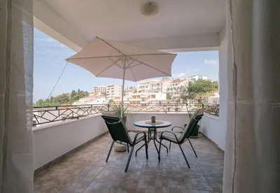 a table and chairs on a balcony with an umbrella at The Rooftop of Apartments Lungo Mare in Ulcinj