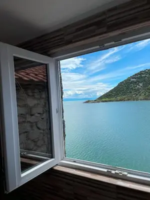a window with a view of the ocean at Lakeview Apartments Jolicic in Virpazar