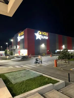 a person riding aooter in front of a building at night at Thousand Roses in Podgorica