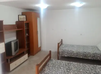 a bedroom with a bed and a tv and a bed gmaxwell gmaxwell gmaxwell at гостевой дом Polina2 in Gornji Sušanj