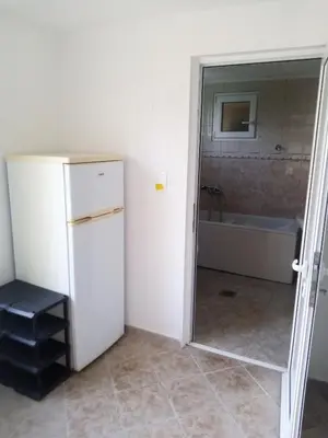 a kitchen with a refrigerator and a bathroom with a tub at гостевой дом Polina2 in Gornji Sušanj