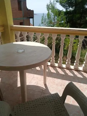 a table and a chair on a balcony at гостевой дом Polina2 in Gornji Sušanj