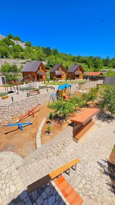 a park with picnic tables and benches and buildings at Vinogradina Eco Vukčević in Virpazar