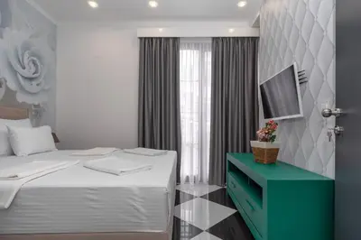 a bedroom with a bed with a blue cabinet and a television at Baba's Hotel & Spa in Dobra Voda