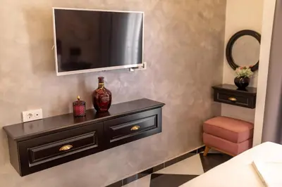 a black dresser with a television on a wall at Baba's Hotel & Spa in Dobra Voda