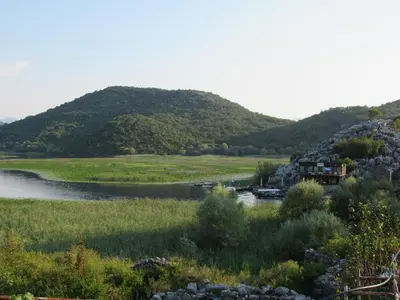 a river with a house on the side of a mountain at Feel the Karuch in Cetinje