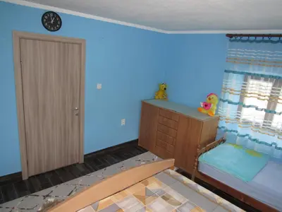 a bedroom with blue walls and a bed with a dresser at Feel the Karuch in Cetinje