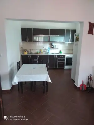 a kitchen with a table in the middle of a room at Dax in Ulcinj