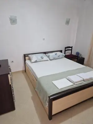 a bedroom with a bed and a small cabinet at Dax in Ulcinj