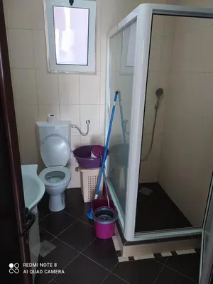 a bathroom with a shower and a toilet with a mop at Dax in Ulcinj
