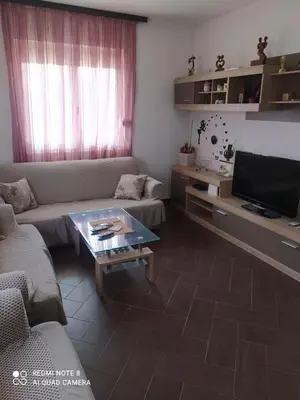 a living room with a couch and a tv at Dax in Ulcinj