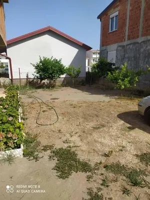 a yard with a hose in front of a house at Dax in Ulcinj