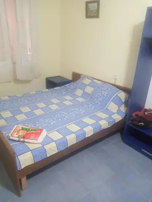 a bedroom with a bed with a book on it at Гостевой дом Polina in Gornji Sušanj