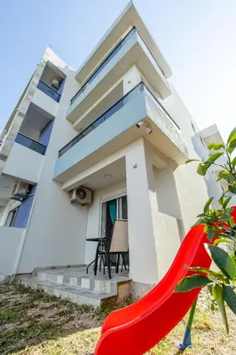 a house with a red slide in front of it at DERON Apartments in Ulcinj