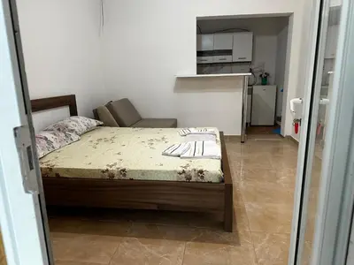 a small bedroom with a bed and a kitchen at Green Villa in Bar, Susanj