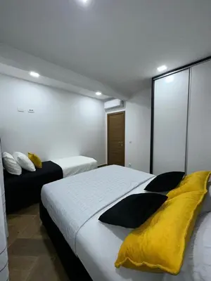 a bedroom with two beds with yellow and black pillows at French Mood in Dobra Voda