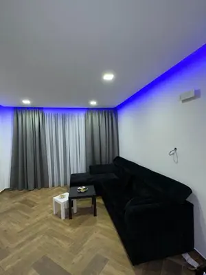 a living room with a black couch and blue lights at French Mood in Dobra Voda