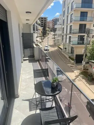 a balcony with a table and chairs and a street at French Mood in Dobra Voda