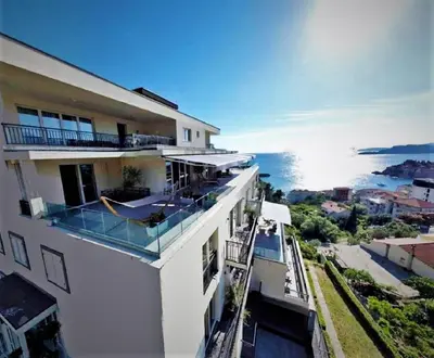 a white building with a view of the ocean at Vertmont Apartments in Sveti Stefan