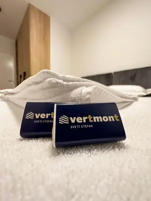 a couple of signs sitting on top of a bed at Vertmont Apartments in Sveti Stefan