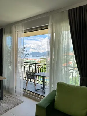 a living room with a view of a balcony at Vertmont Apartments in Sveti Stefan