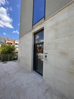 a building with glass doors on the side of it at Мamma Mia Аpartments in Budva