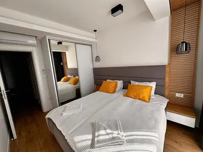 a bedroom with a large bed with orange pillows at Мamma Mia Аpartments in Budva